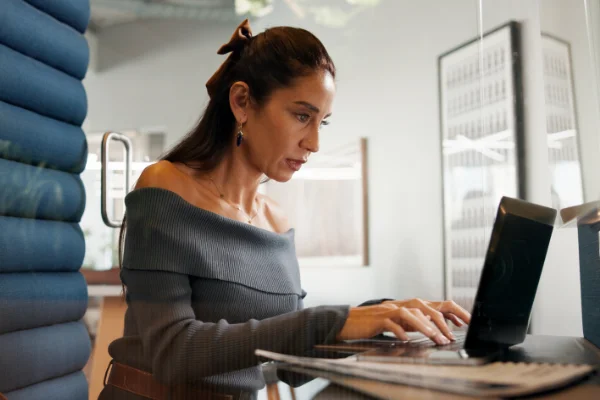 A professional staying up to date with her Dynamics 365 CRM skills on a laptop indoors