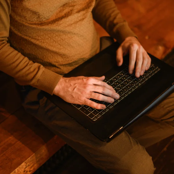 A man working on his laptop at night while learning from a recorded session