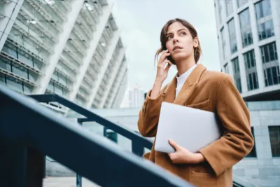 A professional staying up to date with her Microsoft Dynamics 365 skills on a laptop outdoors
