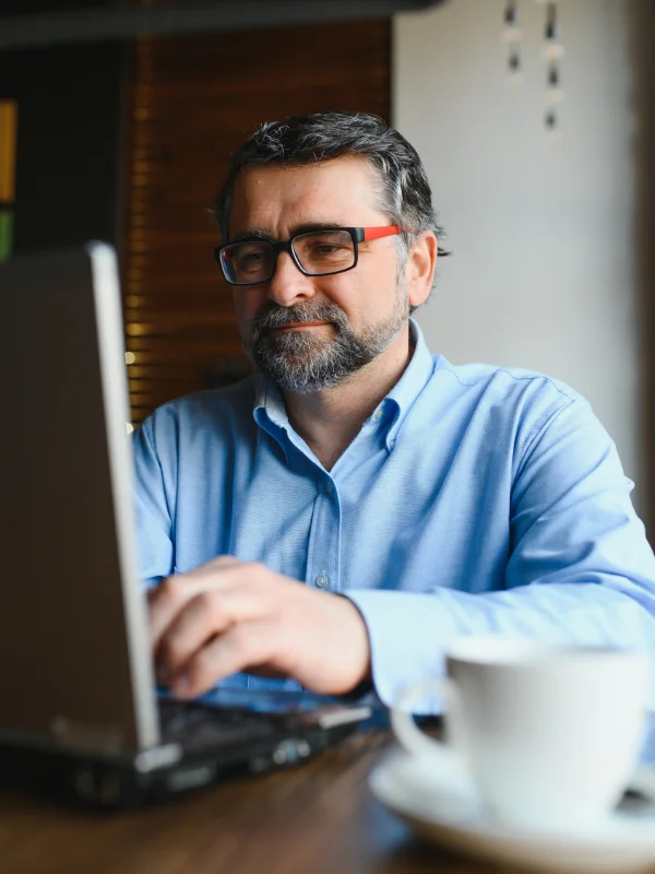 A professional discovering key topics of the Business Central Consultant Learning Journey on a laptop indoors
