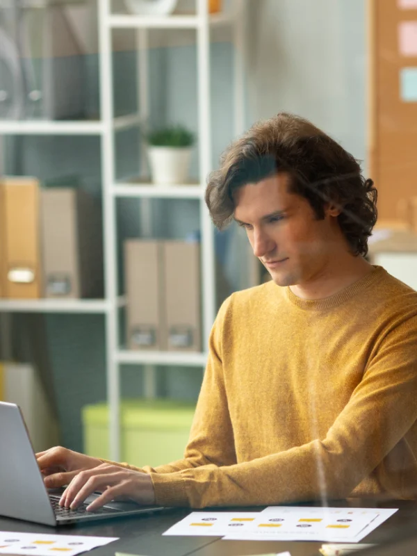 A professional discovering key topics of the Business Central Developer Learning Journey on a laptop indoors